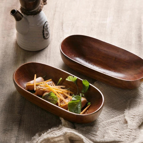 woodnestcraft canoe-shaped acacia wood bowls holding snacks on a rustic table setting