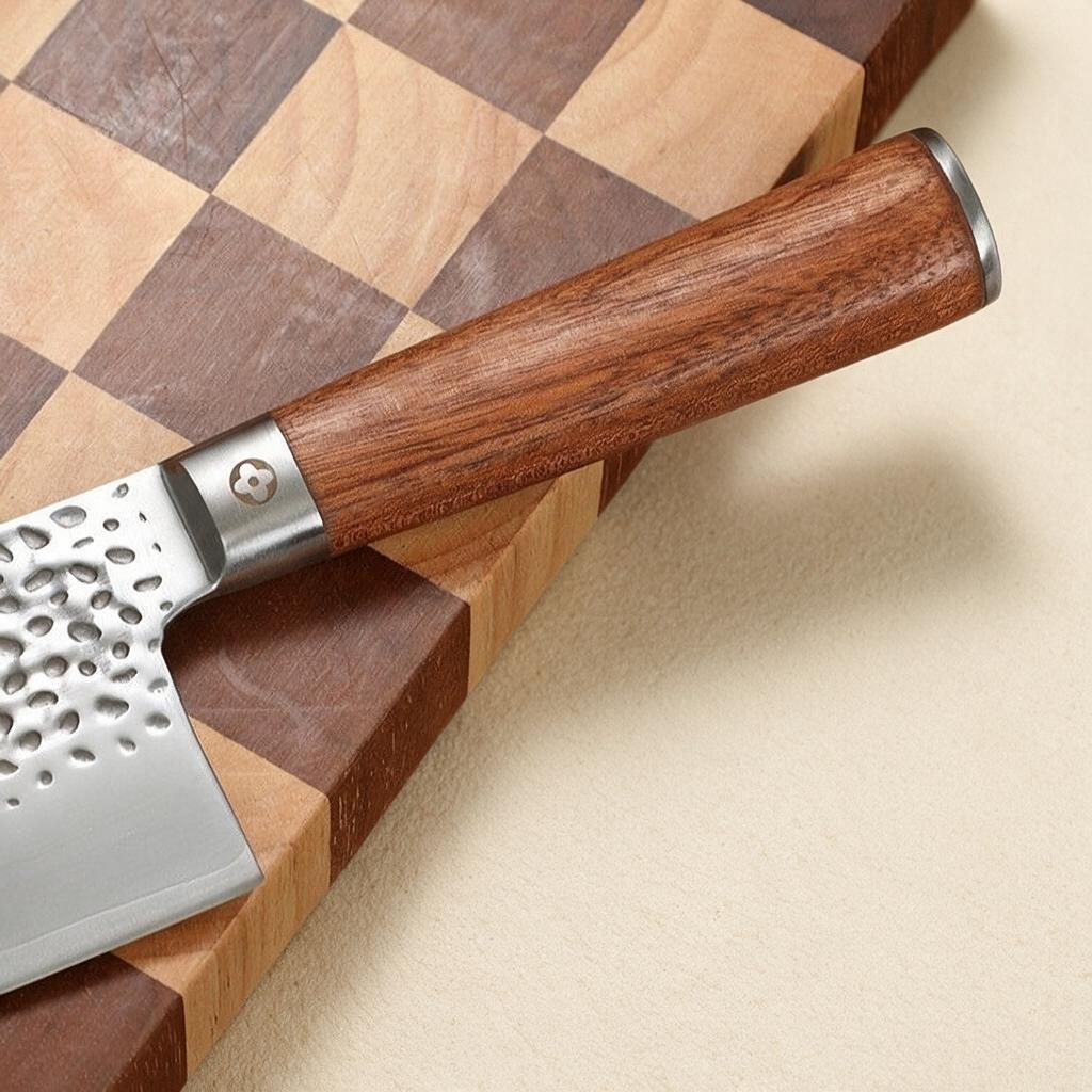 woodnestcraft hand-forged Nakiri knife with a hammered steel blade and an ebony wood handle on a cutting board
