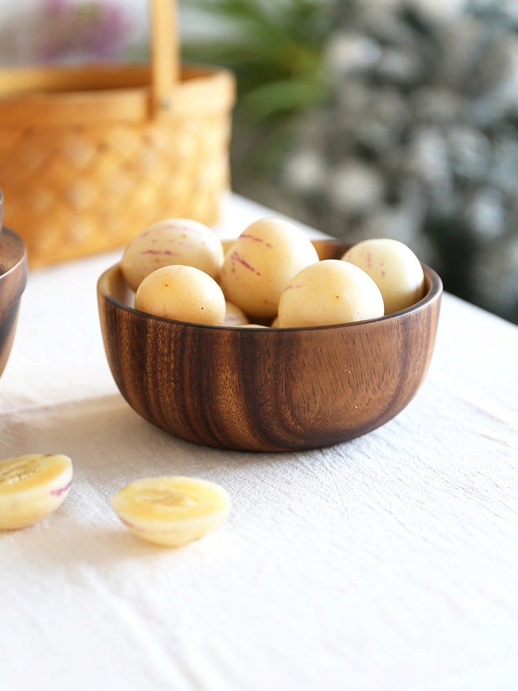 woodnestcraft round solid wood serving bowl filled with fresh pepino melons on a neutral linen tablecloth