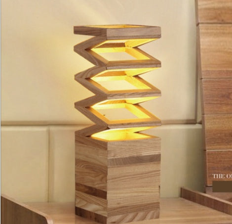 woodnestcraft Fold Lamp featuring a sculptural accordion design made from solid wood with a warm glowing light